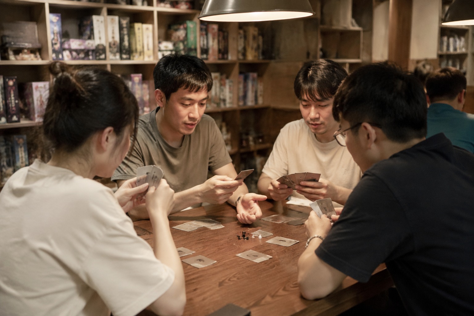 桌游店长桌区围坐一桌玩牌的人